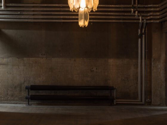Avril Corroon, Sublet Glory, 2026, dehumidifier water (collected from London tenancies), IV bags, crowbar, steel, brass, electric components, carpet, installation view, ‘Flare-Up’ (21 May –16 August 2026) at Goldsmiths Centre for Contemporary Art; photograph by Rob Harris, courtesy of the artist and Goldsmiths CCA.