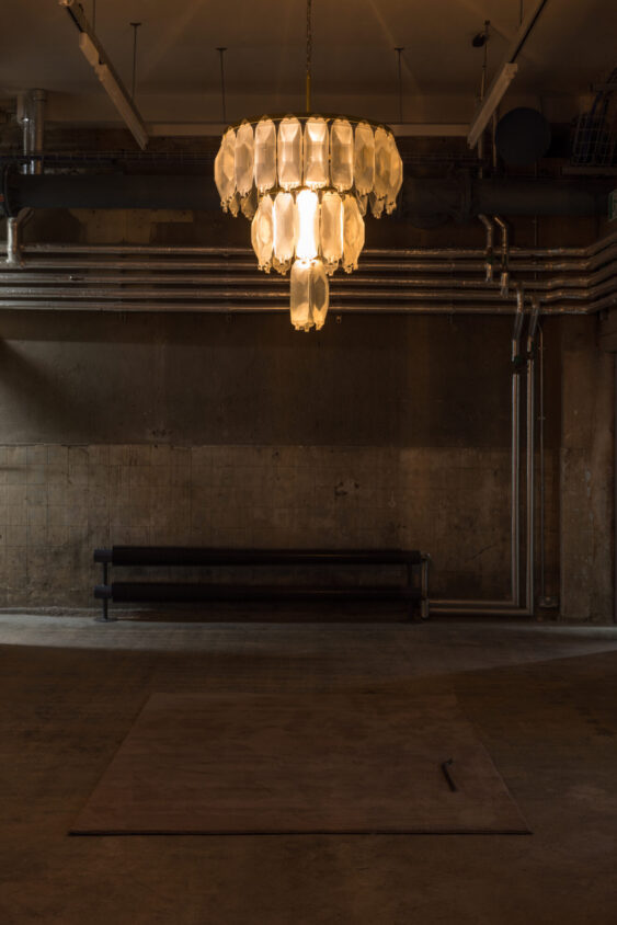 Avril Corroon, Sublet Glory, 2026, dehumidifier water (collected from London tenancies), IV bags, crowbar, steel, brass, electric components, carpet, installation view, ‘Flare-Up’ (21 May –16 August 2026) at Goldsmiths Centre for Contemporary Art; photograph by Rob Harris, courtesy of the artist and Goldsmiths CCA.